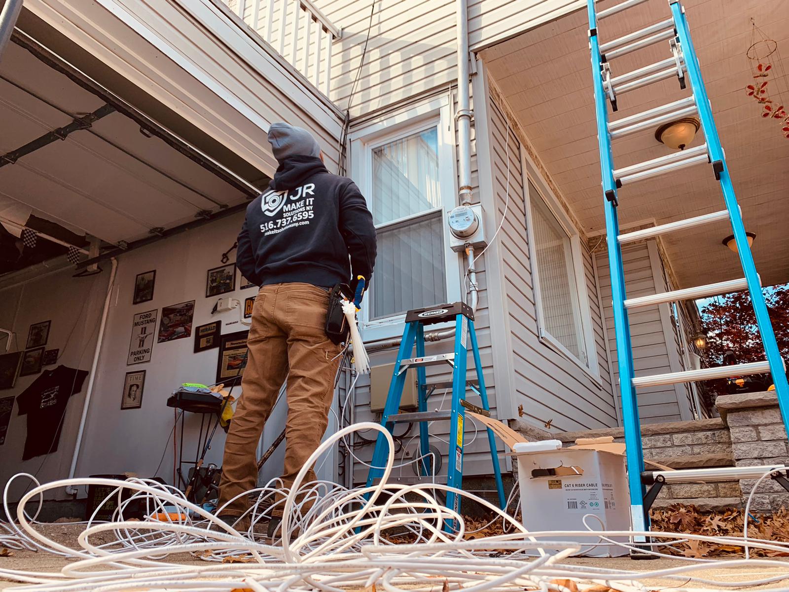 JR Make It Solutions technician pulling Cat6 riser cable for a low voltage wiring install at a New York home